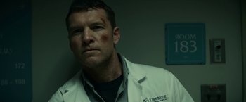 Movie still from “Fractured” (2019), directed by Brad Anderson – A person wearing a lab coat; Close Up shot, Low angle