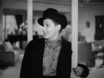 Movie still from “My Favorite Wife” (1940), directed by Garson Kanin – A black and white photo of a woman wearing a hat; Medium shot, Over the shoulder angle