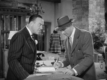 Movie still from “My Favorite Wife” (1940), directed by Garson Kanin – A man in a suit and a man in a hat signing a document; Medium shot, Over the shoulder angle