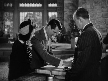 Movie still from “My Favorite Wife” (1940), directed by Garson Kanin – A man and a woman standing next to each other at a counter; Medium shot, Over the shoulder angle