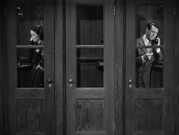 Movie still from “My Favorite Wife” (1940), directed by Garson Kanin – A man and a woman sitting in a doorway; Medium shot, High angle