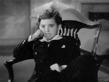 Movie still from “My Favorite Wife” (1940), directed by Garson Kanin – A young man sitting in a chair with his hand on his chin; Medium shot, High angle