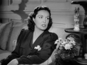Movie still from “My Favorite Wife” (1940), directed by Garson Kanin – A woman sitting on a chair in front of a plant; Close Up shot, High angle