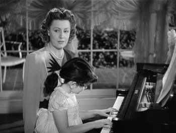 Movie still from “My Favorite Wife” (1940), directed by Garson Kanin – A woman and a little girl are playing a piano together; Medium shot, High angle