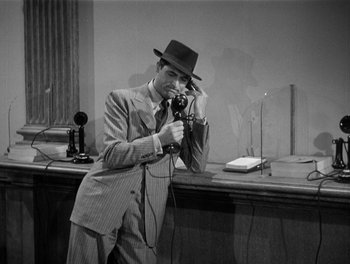 Movie still from “My Favorite Wife” (1940), directed by Garson Kanin – A man in a suit and a hat is holding a phone; Medium shot, High angle