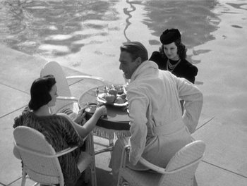 Movie still from “My Favorite Wife” (1940), directed by Garson Kanin – A man and two women sitting at a table; Medium shot, High angle
