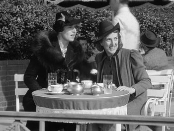 Movie still from “My Favorite Wife” (1940), directed by Garson Kanin – Two women are sitting at a table with tea cups and saucers on it; Medium shot, High angle