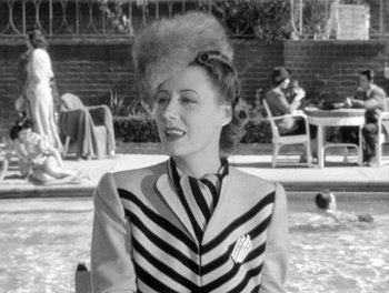 Movie still from “My Favorite Wife” (1940), directed by Garson Kanin – An old photo of a woman in a striped suit; Medium shot, High angle