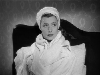 Movie still from “My Favorite Wife” (1940), directed by Garson Kanin – A woman wrapped in a towel sitting in a chair; Close Up shot, High angle