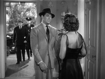 Movie still from “My Favorite Wife” (1940), directed by Garson Kanin – A man and a woman are talking to each other in front of other men; Medium shot, Over the shoulder angle