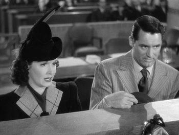 Movie still from “My Favorite Wife” (1940), directed by Garson Kanin – A man and a woman sitting at a table in front of each other; Medium shot, Over the shoulder angle
