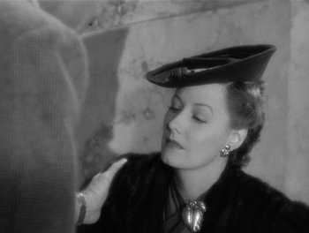 Movie still from “My Favorite Wife” (1940), directed by Garson Kanin – An old black and white photo of a woman wearing a hat; Close Up shot, Over the shoulder angle