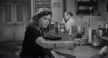Movie still from “My Gun Is Quick” (1957), directed by Victor Saville – A woman sitting at a table in front of a man; Medium shot, Over the shoulder angle