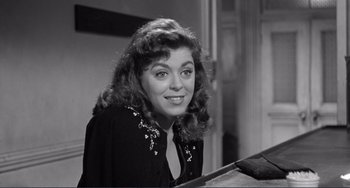 Movie still from “My Gun Is Quick” (1957), directed by Victor Saville – A black - and - white photo of a woman smiling at the camera; Close Up shot, High angle