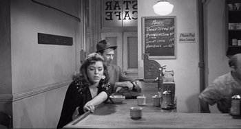 Movie still from “My Gun Is Quick” (1957), directed by Victor Saville – A man and a woman sitting at a counter; Medium shot, High angle