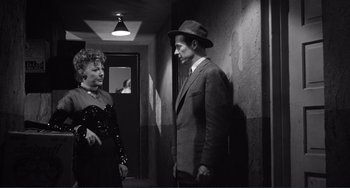 Movie still from “My Gun Is Quick” (1957), directed by Victor Saville – A man and a woman standing in a hallway; Medium shot, Over the shoulder angle