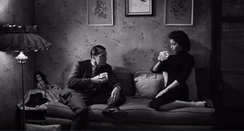 Movie still from “My Gun Is Quick” (1957), directed by Victor Saville – A man and a woman sitting on a couch drinking coffee; Medium shot, High angle