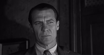 Movie still from “My Gun Is Quick” (1957), directed by Victor Saville – Black and white photograph of a man in a suit and tie; Close Up shot, Low angle