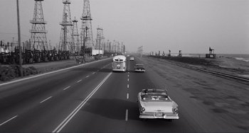 Movie still from “My Gun Is Quick” (1957), directed by Victor Saville – A black and white photo of cars on a highway; Extreme Wide shot, High angle