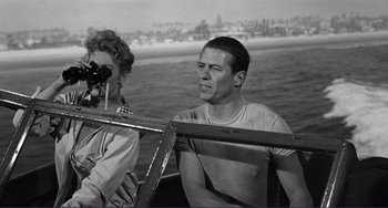 Movie still from “My Gun Is Quick” (1957), directed by Victor Saville – A man sitting on a boat in the water; Medium shot, Over the shoulder angle