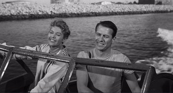 Movie still from “My Gun Is Quick” (1957), directed by Victor Saville – A man and a woman sitting on a boat; Medium shot, Low angle