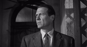 Movie still from “My Gun Is Quick” (1957), directed by Victor Saville – Black and white photograph of a man wearing a suit and tie; Close Up shot, Low angle