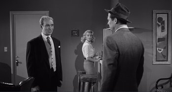 Movie still from “My Gun Is Quick” (1957), directed by Victor Saville – Two men and a woman standing in front of a bar; Medium shot, Over the shoulder angle