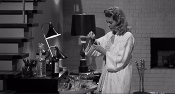 Movie still from “My Gun Is Quick” (1957), directed by Victor Saville – A black and white photo of a woman preparing a drink; Medium shot, Low angle