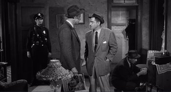 Movie still from “My Gun Is Quick” (1957), directed by Victor Saville – Two men in suits and hats talking to each other; Medium shot, High angle
