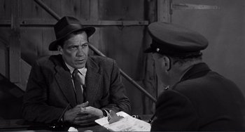 Movie still from “My Gun Is Quick” (1957), directed by Victor Saville – A man wearing a hat and a suit talking to another man in a hat; Medium shot, Over the shoulder angle