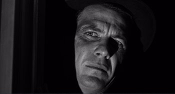 Movie still from “My Gun Is Quick” (1957), directed by Victor Saville – A black and white photo of a man's face; Close Up shot, Low angle