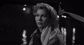 Movie still from “My Gun Is Quick” (1957), directed by Victor Saville – A black and white photo of a woman with a scarf around her head; Close Up shot, Low angle