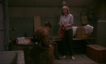 Movie still from “My Life as a Dog” (1985), directed by Lasse Hallström – A woman in a white shirt and a man in a brown jacket; Medium shot, Over the shoulder angle