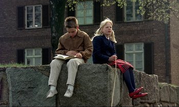 Movie still from “My Life as a Dog” (1985), directed by Lasse Hallström – Two young children sitting on a rock outside; Wide shot, Low angle