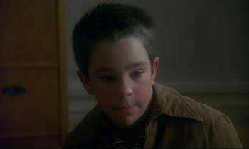 Movie still from “My Life as a Dog” (1985), directed by Lasse Hallström – A young boy is looking into the distance; Close Up shot, High angle
