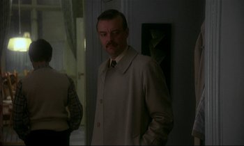 Movie still from “My Life as a Dog” (1985), directed by Lasse Hallström – A man in a suit and tie standing next to a woman; Medium shot, Over the shoulder angle