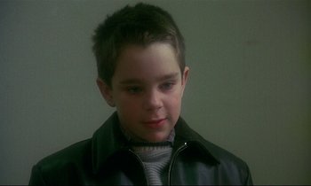 Movie still from “My Life as a Dog” (1985), directed by Lasse Hallström – A young boy wearing a leather jacket and a sweater; Close Up shot, High angle