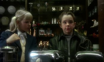 Movie still from “My Life as a Dog” (1985), directed by Lasse Hallström – Two young children are standing in a room; Close Up shot, Over the shoulder angle