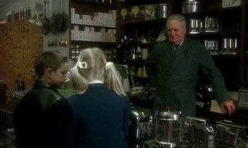 Movie still from “My Life as a Dog” (1985), directed by Lasse Hallström – A group of people standing in a room; Medium shot, Over the shoulder angle