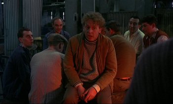 Movie still from “My Life as a Dog” (1985), directed by Lasse Hallström – A group of men sitting in a room together; Medium shot, High angle