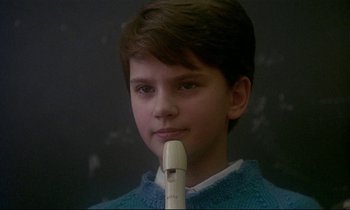 Movie still from “My Life as a Dog” (1985), directed by Lasse Hallström – A young boy is holding a plastic pipe in front of his face; Close Up shot, Low angle