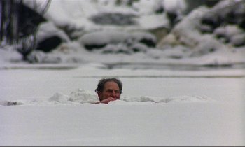 Movie still from “My Life as a Dog” (1985), directed by Lasse Hallström – A man swimming in a body of snow; Wide shot, High angle