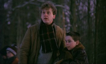 Movie still from “My Life as a Dog” (1985), directed by Lasse Hallström – A man standing next to a young boy in a forest; Medium shot, Low angle