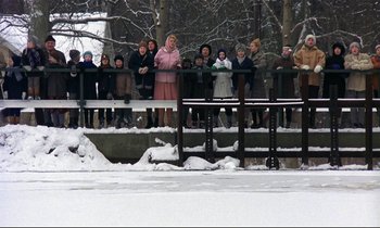 Movie still from “My Life as a Dog” (1985), directed by Lasse Hallström – A group of people standing on top of a wooden bridge; Extreme Wide shot, High angle