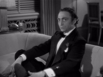 Movie still from “My Man Godfrey” (1936), directed by Gregory La Cava – Black and white photograph of a man sitting on a couch; Medium shot, High angle
