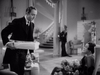 Movie still from “My Man Godfrey” (1936), directed by Gregory La Cava – A man in a suit and tie holding a piece of paper in his hand; Medium shot, High angle