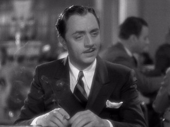 Movie still from “My Man Godfrey” (1936), directed by Gregory La Cava – A man in a suit and tie sitting at a table; Close Up shot, Over the shoulder angle