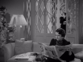 Movie still from “My Man Godfrey” (1936), directed by Gregory La Cava – A woman sitting on a couch while reading a newspaper; Medium shot, High angle