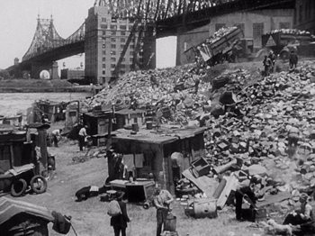 Movie still from “My Man Godfrey” (1936), directed by Gregory La Cava – An old photo of a pile of rubble in the middle of a city; Extreme Wide shot, High angle