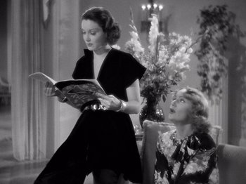 Movie still from “My Man Godfrey” (1936), directed by Gregory La Cava – A woman sitting next to another woman while holding a book; Medium shot, Low angle